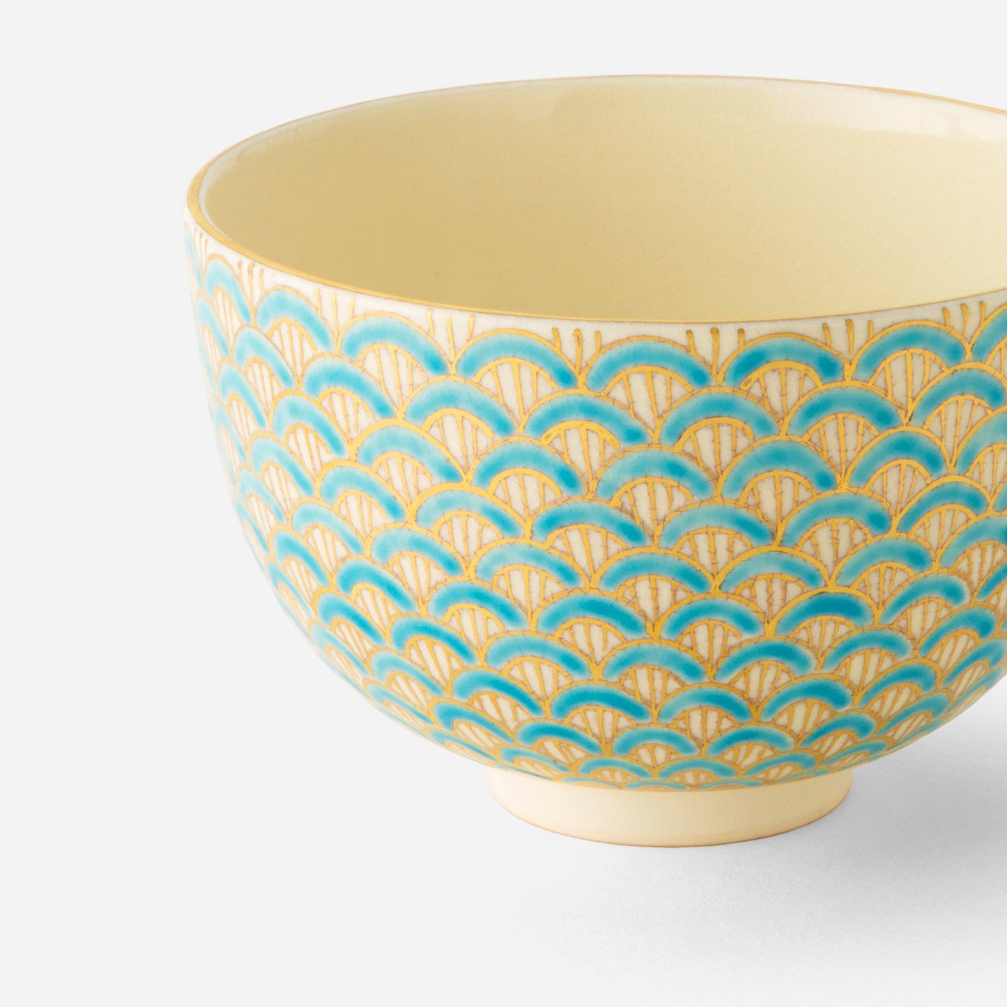 Handcrafted Japanese matcha bowl with golden purple seigaiha wave pattern, featuring an intricate design of overlapping semicircles in rich purple and gold on a cream background