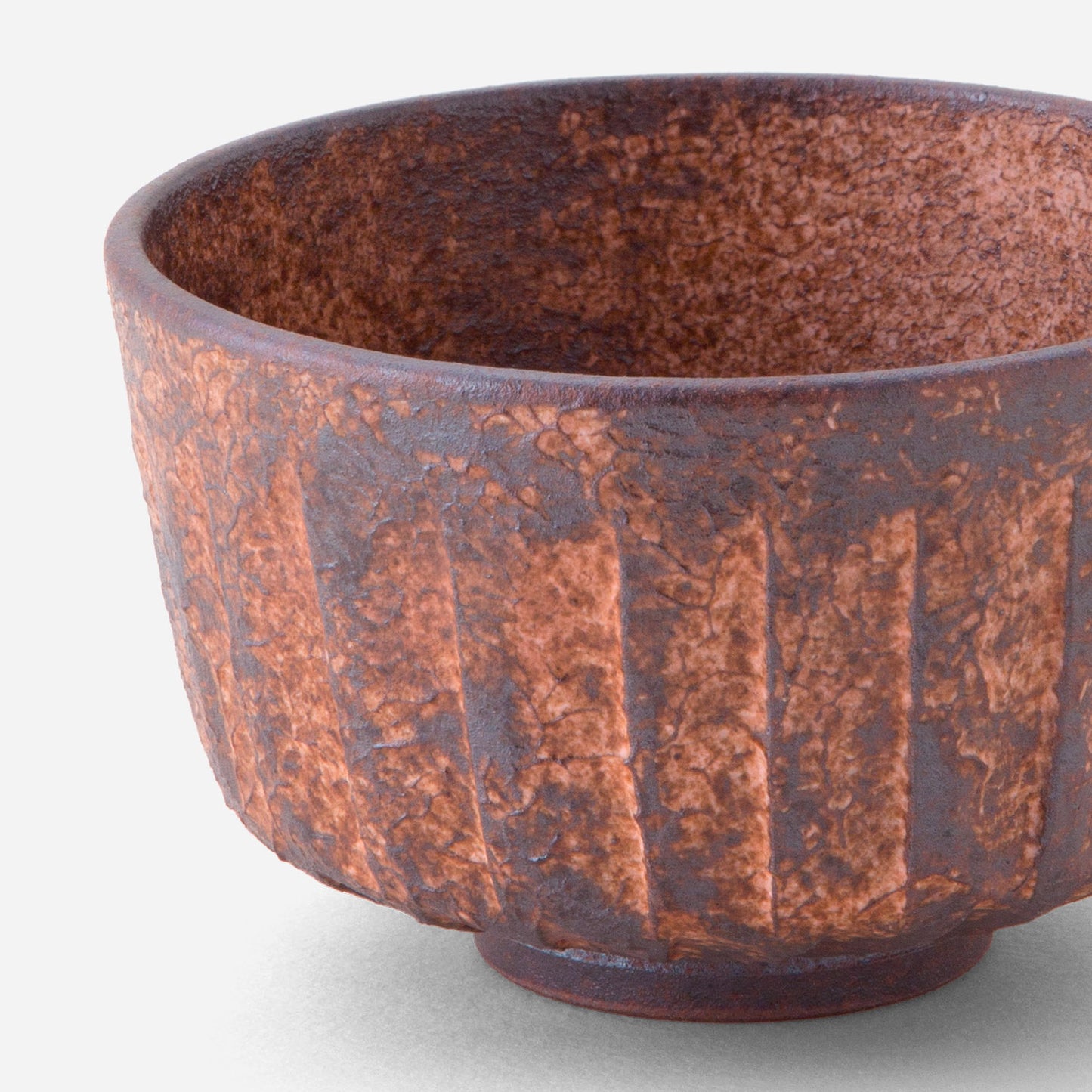 Handcrafted Japanese matcha bowl with rustic sogi (fluted) pattern, featuring a rich reddish-brown glaze reminiscent of sun-baked earth