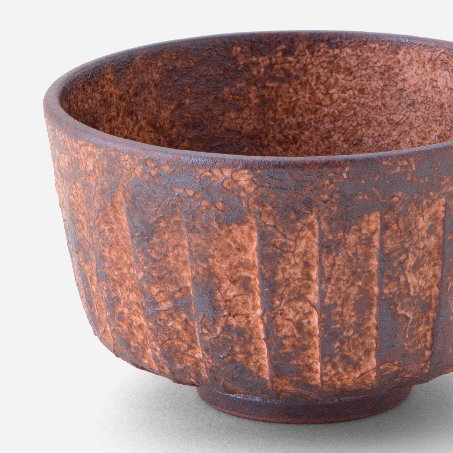 Handcrafted Japanese matcha bowl with rustic sogi (fluted) pattern, featuring a rich reddish-brown glaze reminiscent of sun-baked earth