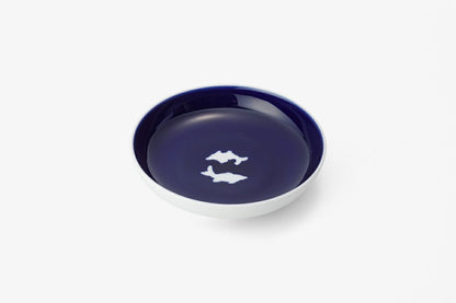 Deep blue ceramic plate with white twin fish design, showcasing Ming dynasty techniques and Japanese aesthetic principles