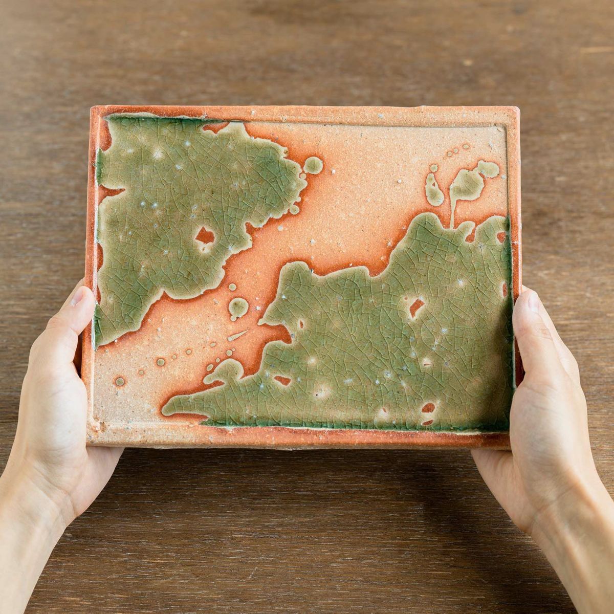 Handcrafted large Koshinraku square ceramic plate with unique green glaze pattern and natural clay accents, showcasing traditional Japanese pottery techniques