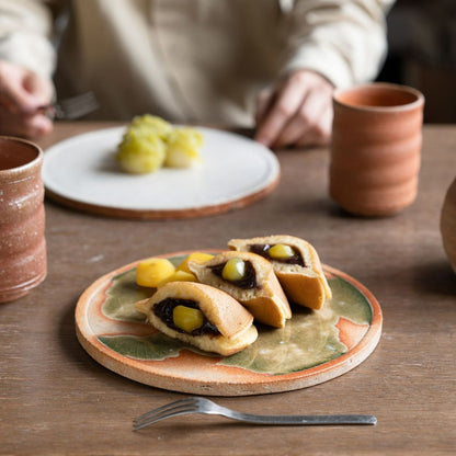 Handcrafted large Koshinraku round ceramic plate with green glazed center and natural clay rim, showcasing traditional Japanese pottery techniques