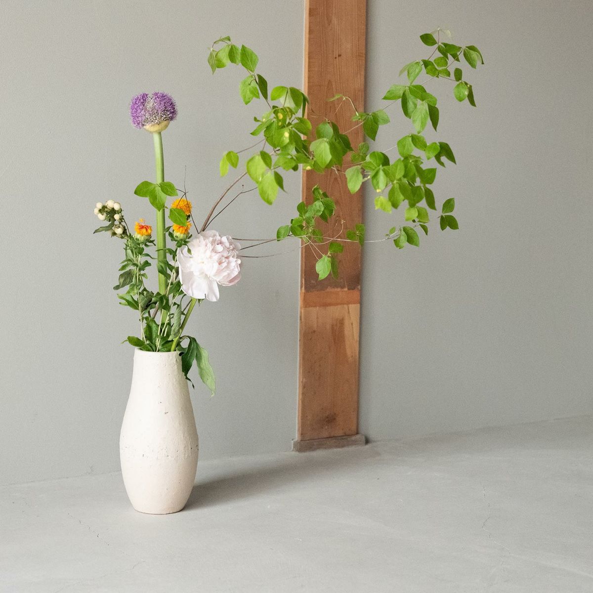 HIBI Shigaraki Ceramic Flower Vase from Natural White Series, featuring traditional pottery techniques and unique stone inclusions, displayed with a colorful floral arrangement