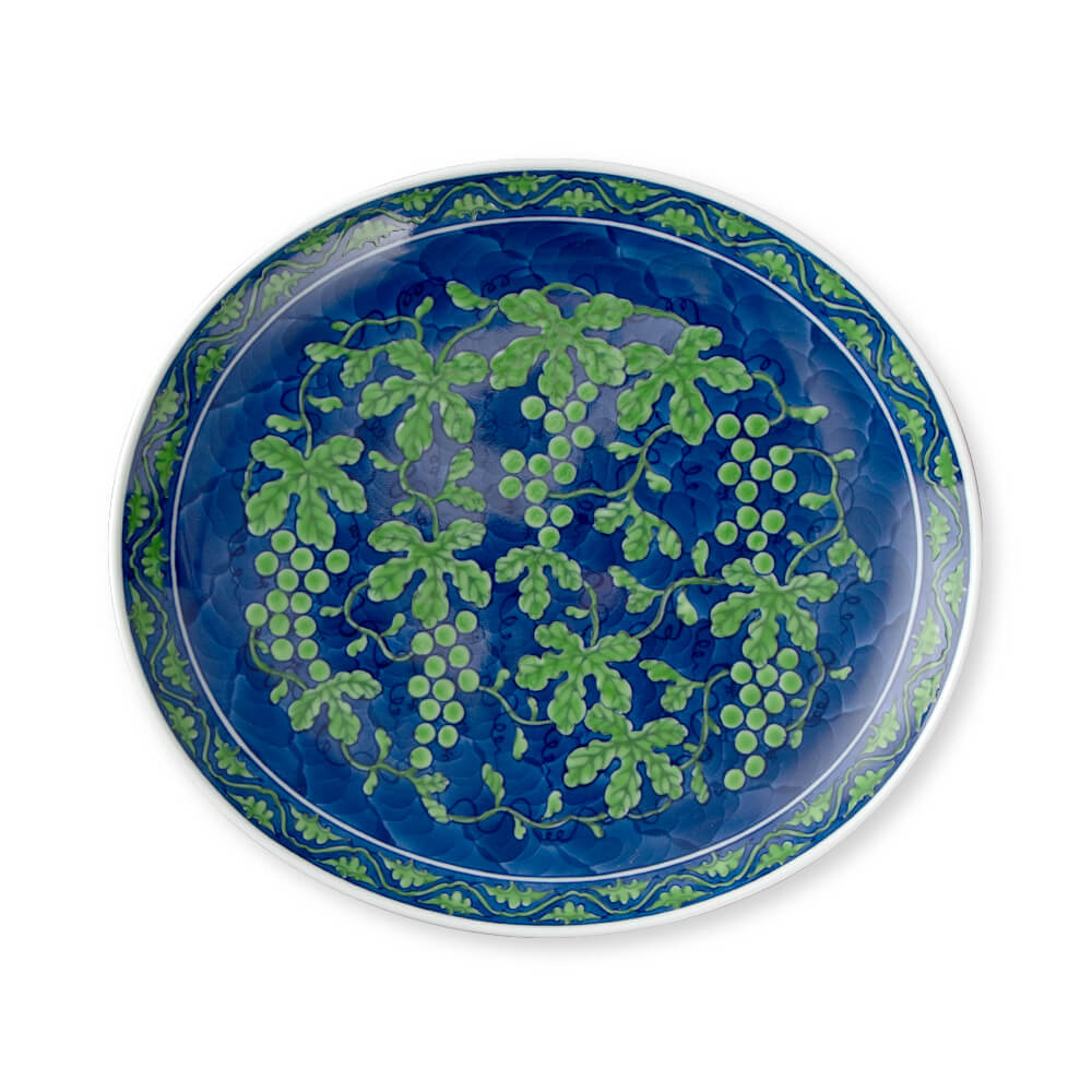 Large handcrafted Japanese oval platter featuring intricate green grapevine design on deep blue background, perfect for serving and display