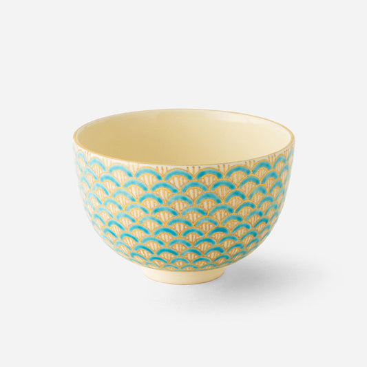 Handcrafted Japanese matcha bowl with golden purple seigaiha wave pattern, featuring an intricate design of overlapping semicircles in rich purple and gold on a cream background