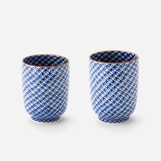 Handcrafted Japanese teacup set with blue sometsuke shippo pattern, featuring two cups with intricate designs of overlapping circles in cobalt blue on a white background with copper-colored rims