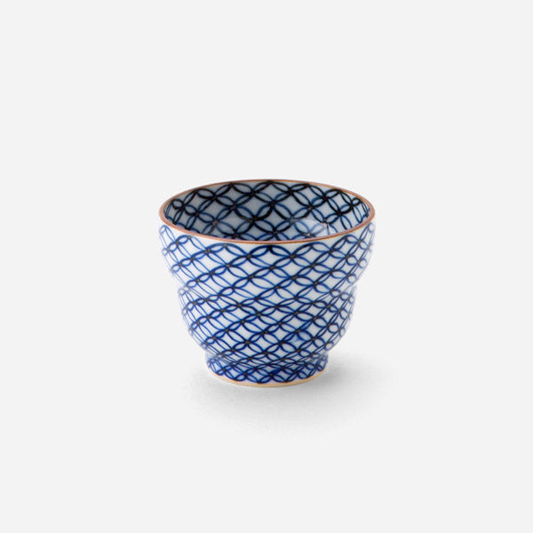 Handcrafted Japanese sake cup with blue sometsuke shippo pattern, featuring an intricate design of overlapping circles in cobalt blue on a white background with a copper-colored rim