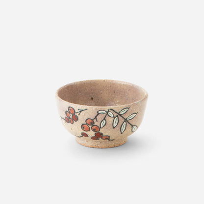 Handcrafted Japanese sake cup with nanten berry design, featuring delicate red berries and green leaves hand-painted on a warm, earthy base