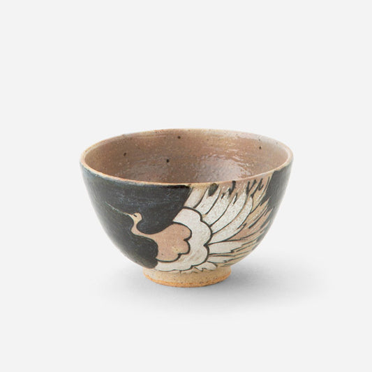 Handcrafted Japanese tea bowl with iron-glazed crane motif, featuring a graceful crane design in light tones against a deep black exterior