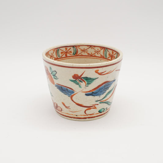 Traditional Japanese Goshiki Akae teacup featuring a hand-painted crane design in vibrant colors on a cream background, showcasing exquisite craftsmanship