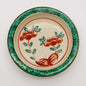 Small ceramic dish with hand-painted red flowers and green border, showcasing traditional Japanese akae style artwork