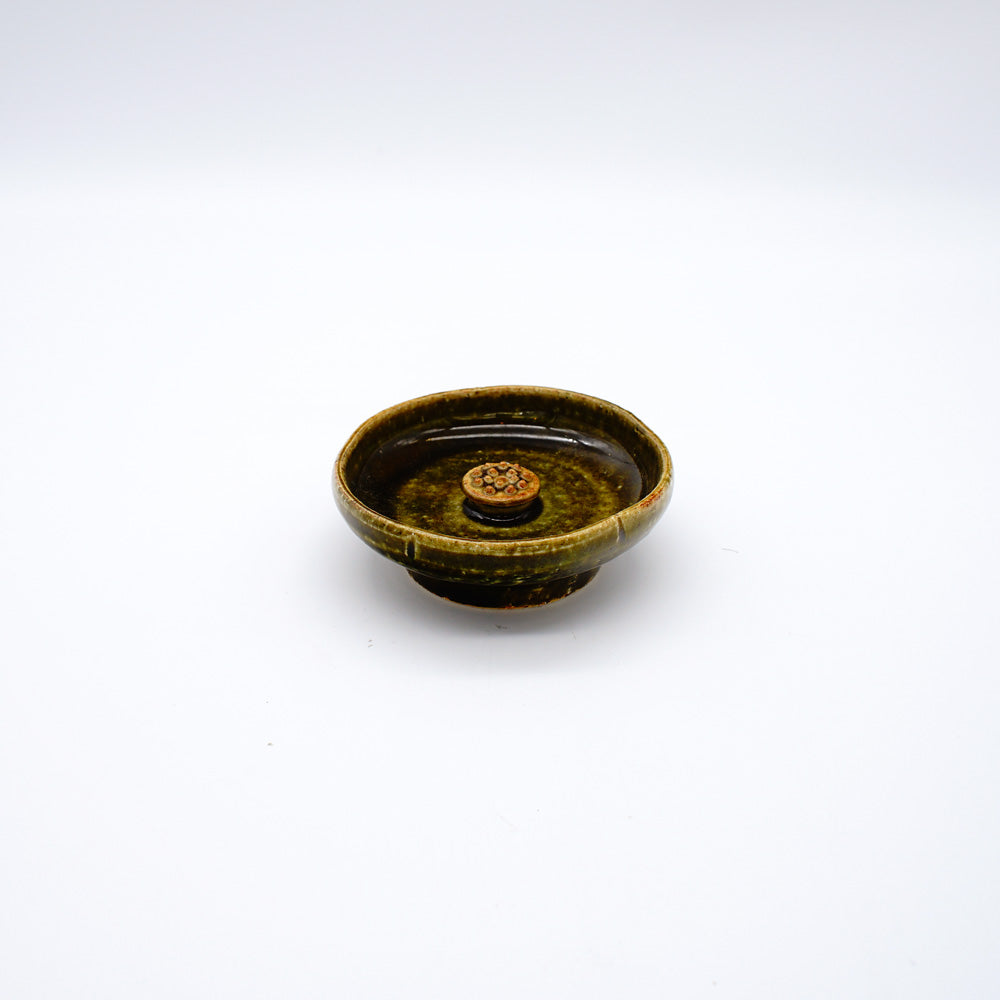 Oribe-style ceramic incense holder with deep green glaze and central platform, designed for meditation and mindfulness practices