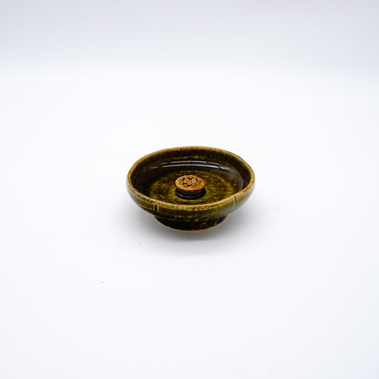 Oribe-style ceramic incense holder with deep green glaze and central platform, designed for meditation and mindfulness practices