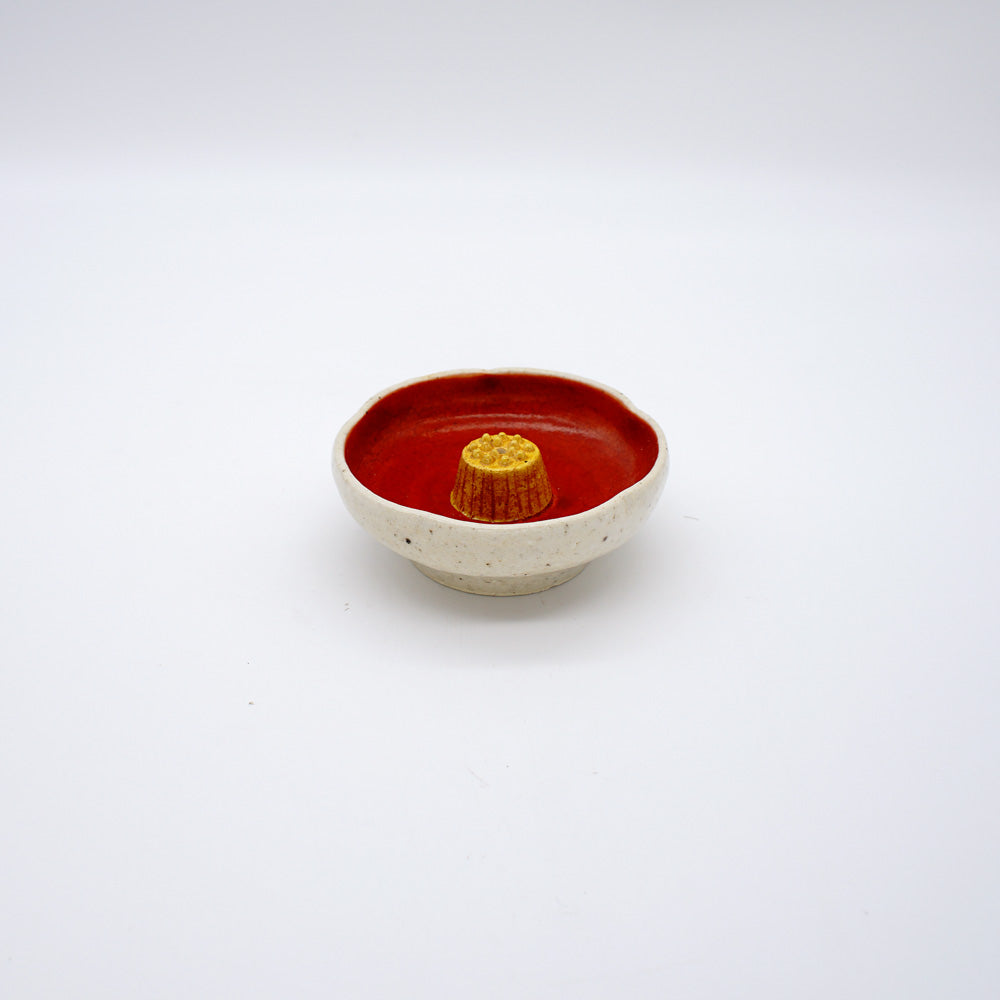 Ceramic incense holder with natural exterior, red interior, and golden center, designed for meditation and mindfulness practices