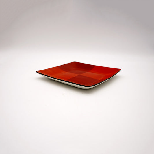 Angular ceramic plate with vibrant red layered checkered pattern and white rim, showcasing modern Japanese-inspired design