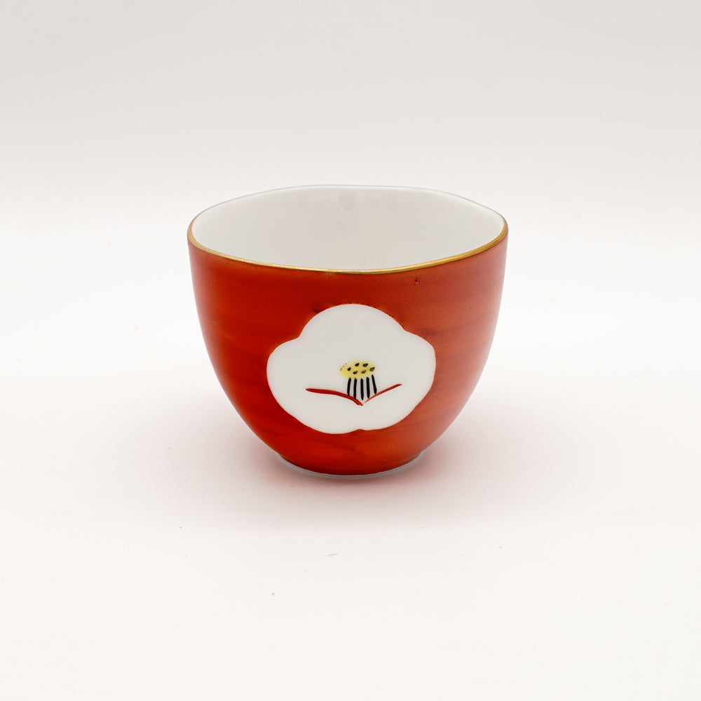 Crimson red tea cup with a delicate white plum blossom design, showcasing exquisite Japanese ceramic craftsmanship